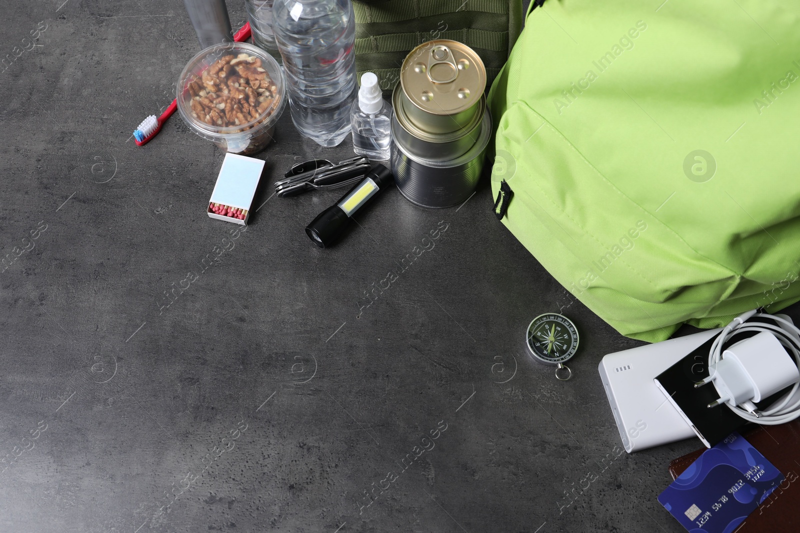 Survival kit. Different emergency supplies on grey table, above view. Space for text Photo of Survival kit. Different emergency supplies on grey table, above view. Space for text
