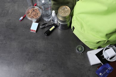 Photo of Survival kit. Different emergency supplies on grey table, above view. Space for text
