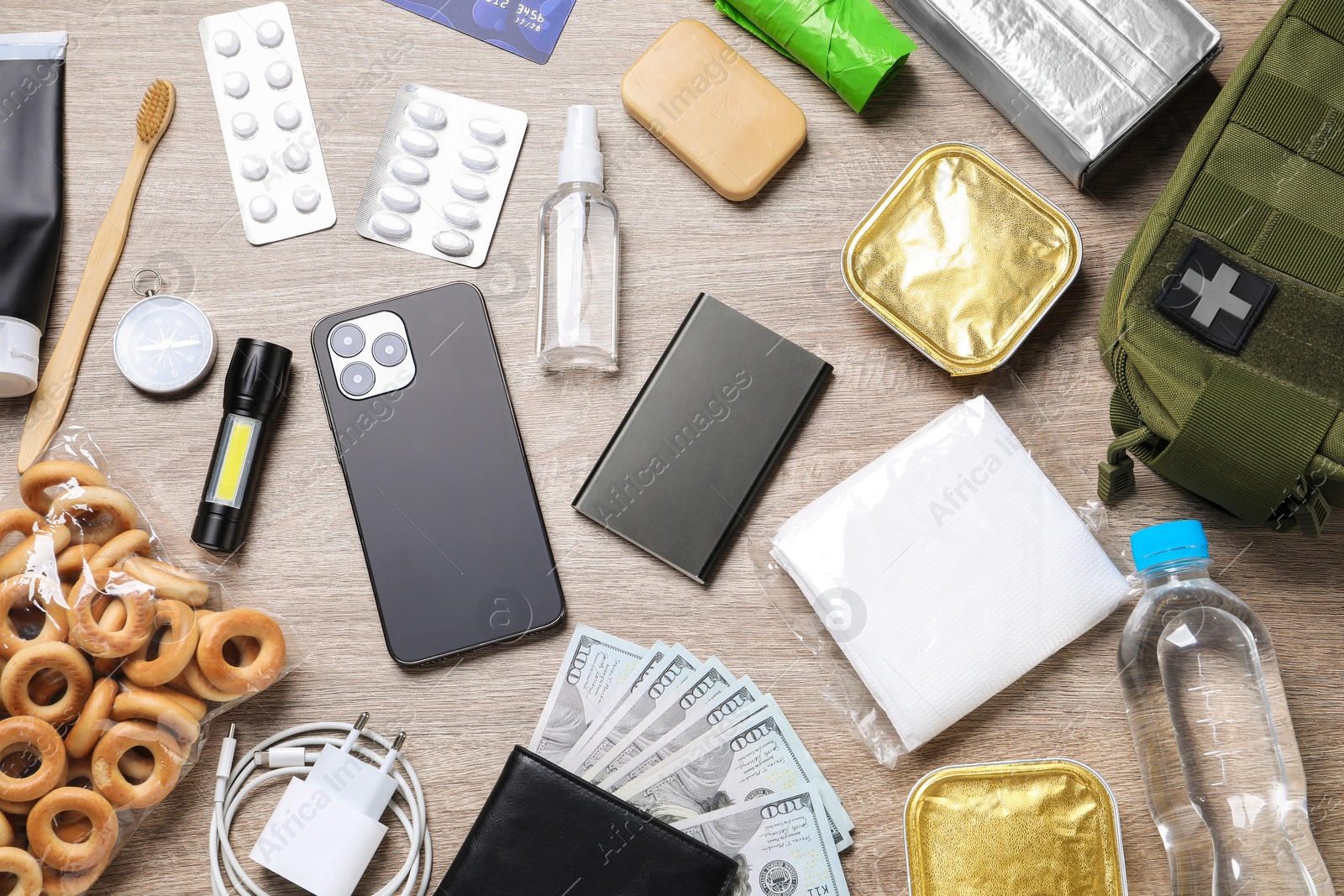 Survival kit. Different emergency supplies on wooden table, flat lay Photo of Survival kit. Different emergency supplies on wooden table, flat lay