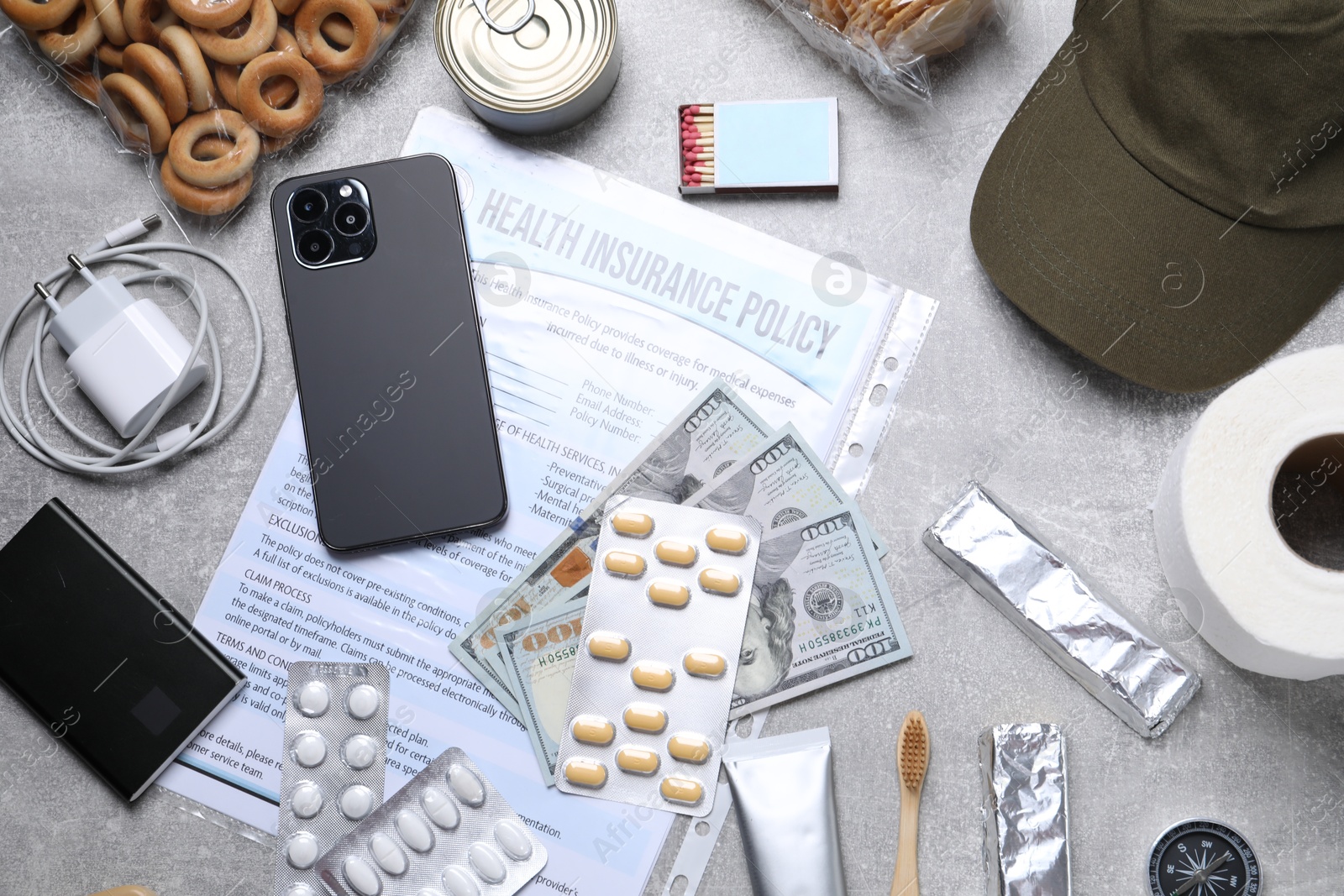 Survival kit. Different emergency supplies on grey table, flat lay Photo of Survival kit. Different emergency supplies on grey table, flat lay