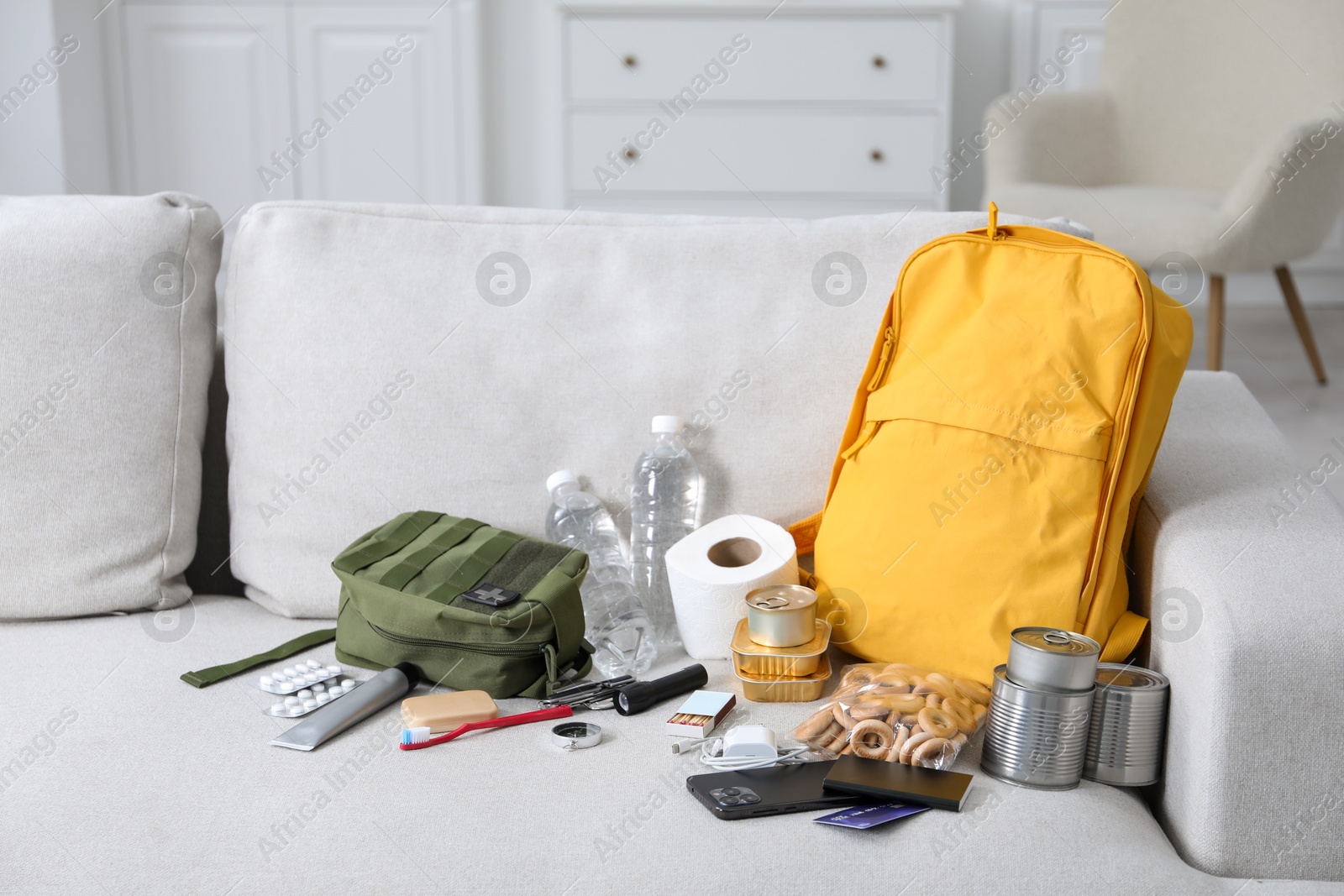 Survival kit. Different emergency supplies on sofa indoors Photo of Survival kit. Different emergency supplies on sofa indoors