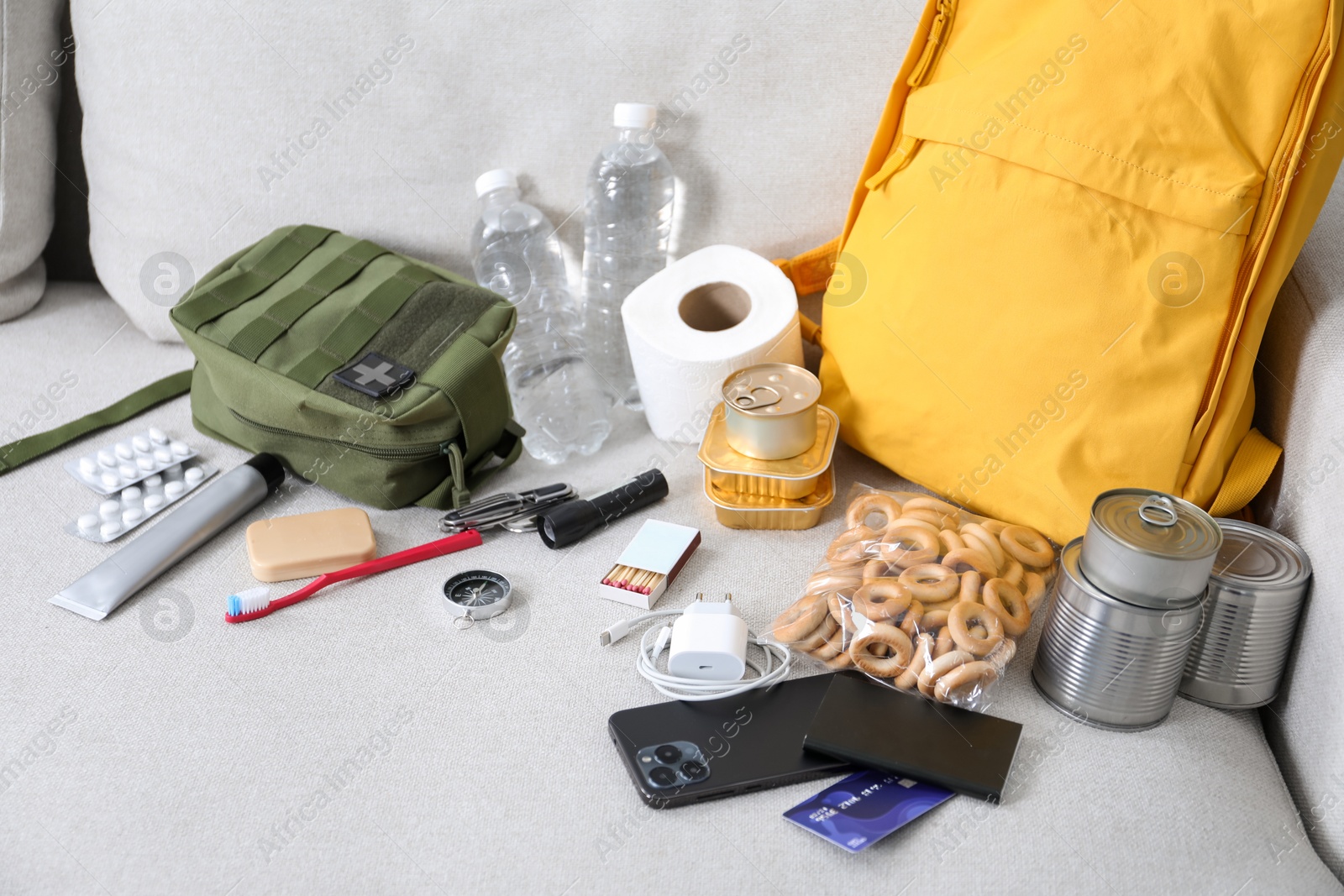 Survival kit. Different emergency supplies on sofa indoors Photo of Survival kit. Different emergency supplies on sofa indoors
