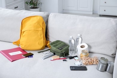 Photo of Survival kit. Different emergency supplies on sofa indoors