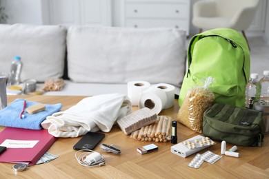 Photo of Survival kit. Different emergency supplies on wooden table indoors