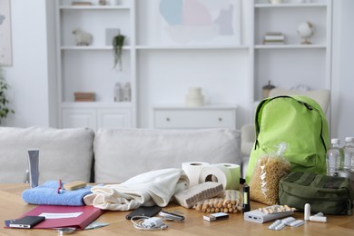 Photo of Survival kit. Different emergency supplies on wooden table indoors