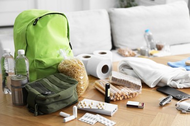 Photo of Survival kit. Different emergency supplies on wooden table indoors