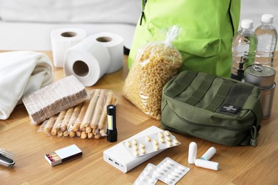 Photo of Survival kit. Different emergency supplies on wooden table indoors