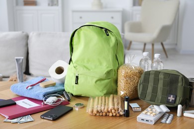 Photo of Survival kit. Different emergency supplies on wooden table indoors