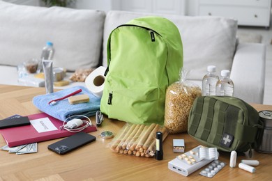 Photo of Survival kit. Different emergency supplies on wooden table indoors