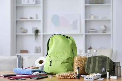 Photo of Survival kit. Different emergency supplies on wooden table indoors