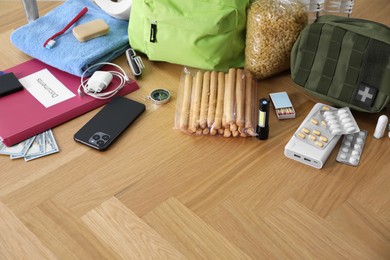 Photo of Survival kit. Different emergency supplies on wooden table indoors, space for text