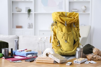Photo of Survival kit. Different emergency supplies on wooden table indoors