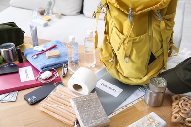 Photo of Survival kit. Different emergency supplies on wooden table indoors