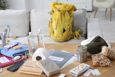 Photo of Survival kit. Different emergency supplies on wooden table indoors