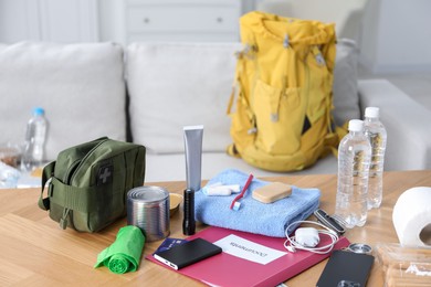 Photo of Survival kit. Different emergency supplies on wooden table indoors