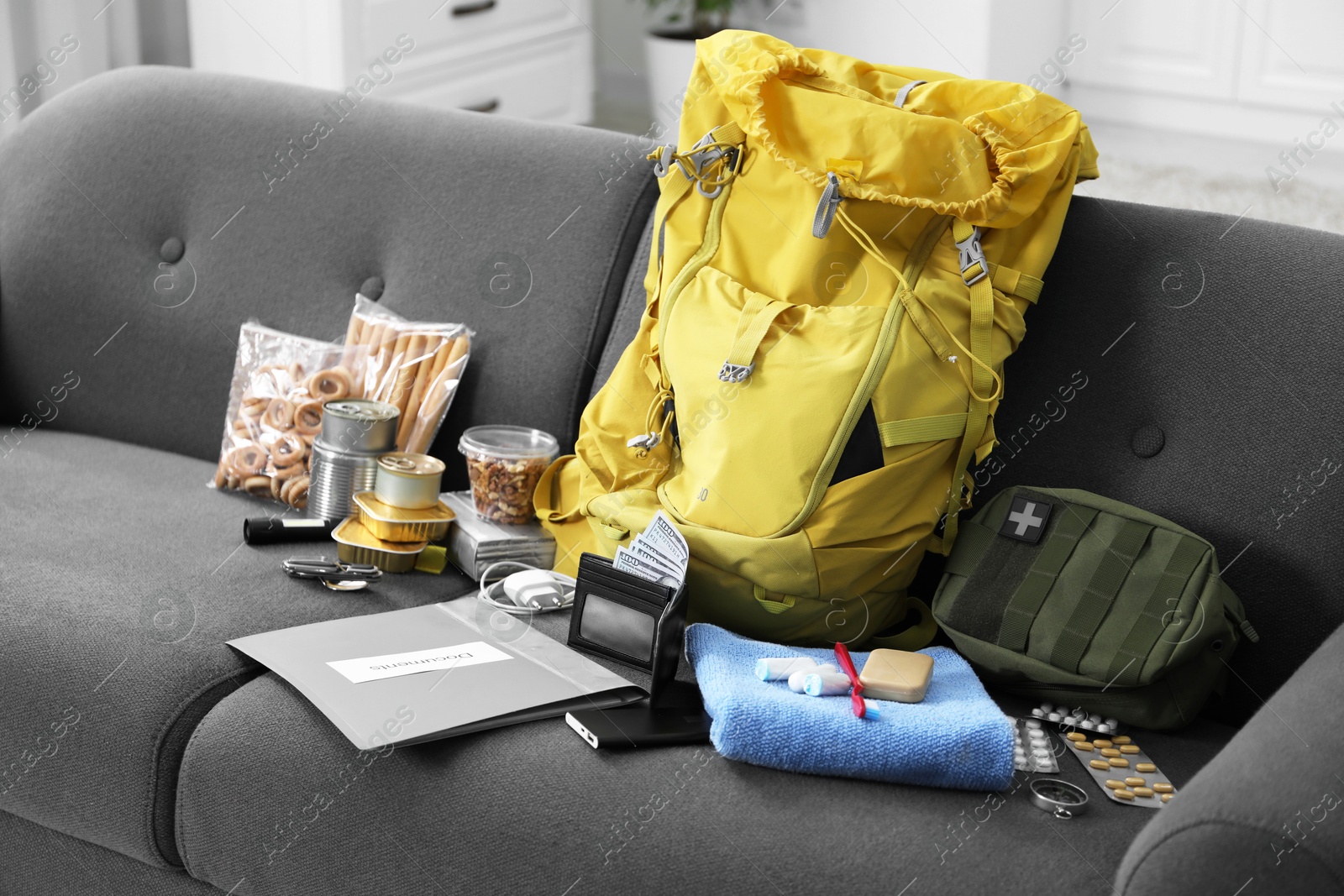 Survival kit. Different emergency supplies on sofa indoors Photo of Survival kit. Different emergency supplies on sofa indoors