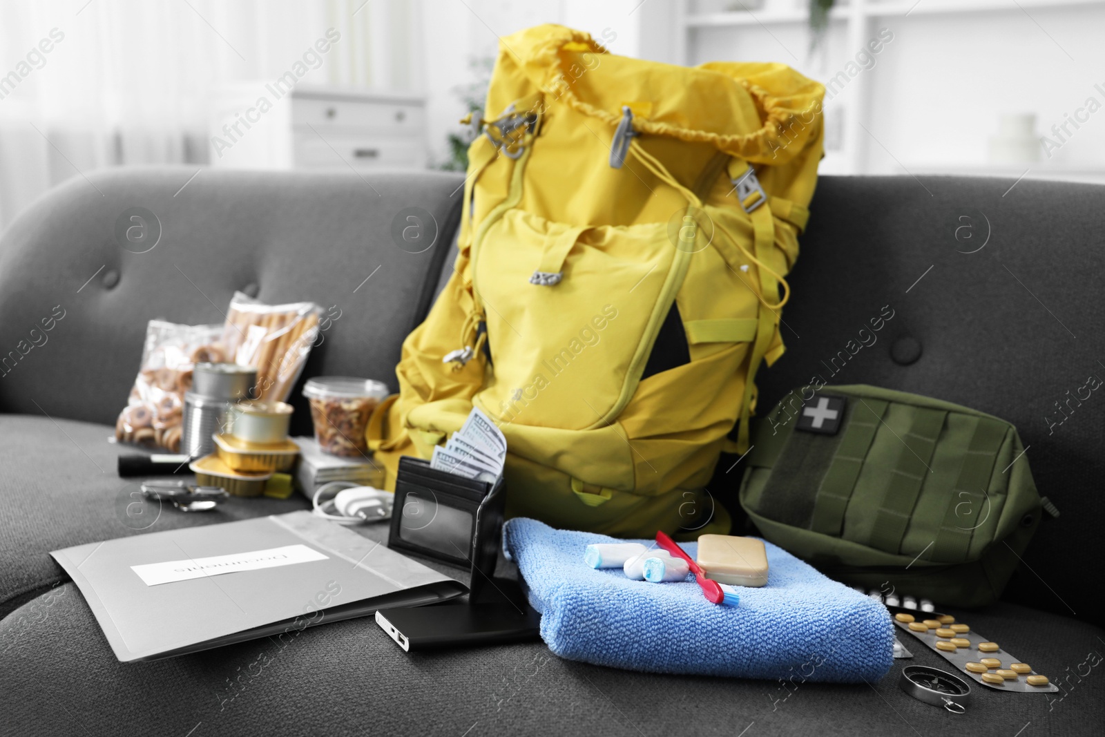 Survival kit. Different emergency supplies on sofa indoors Photo of Survival kit. Different emergency supplies on sofa indoors