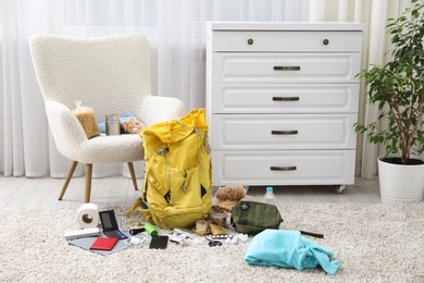 Photo of Survival kit. Different emergency supplies on floor indoors