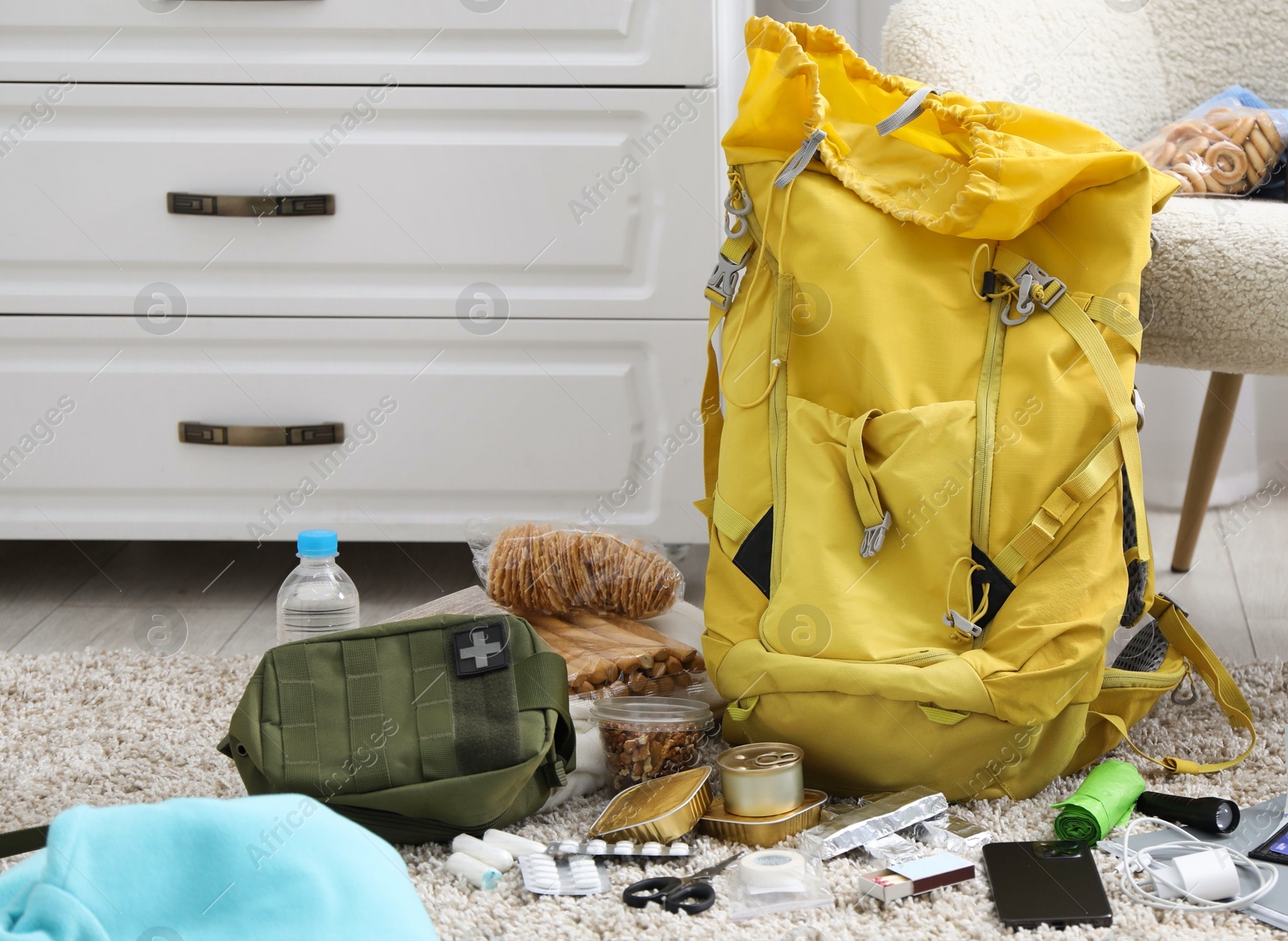 Survival kit. Different emergency supplies on floor indoors Photo of Survival kit. Different emergency supplies on floor indoors