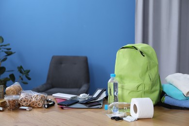 Photo of Survival kit. Different emergency supplies on wooden table indoors