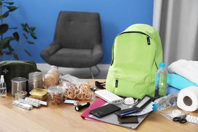 Photo of Survival kit. Different emergency supplies on wooden table indoors