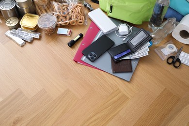 Photo of Survival kit. Different emergency supplies on wooden table indoors, above view