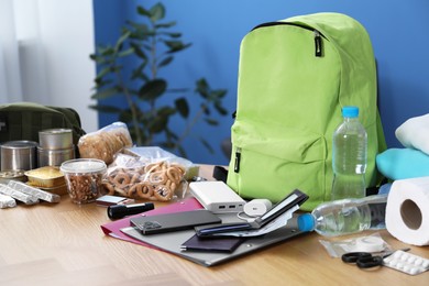 Photo of Survival kit. Different emergency supplies on wooden table indoors