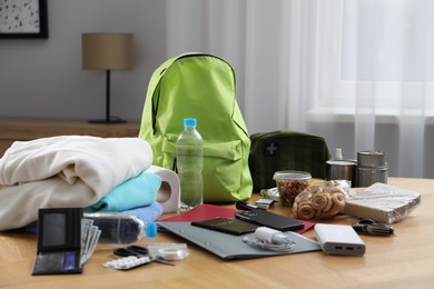 Photo of Survival kit. Different emergency supplies on wooden table indoors
