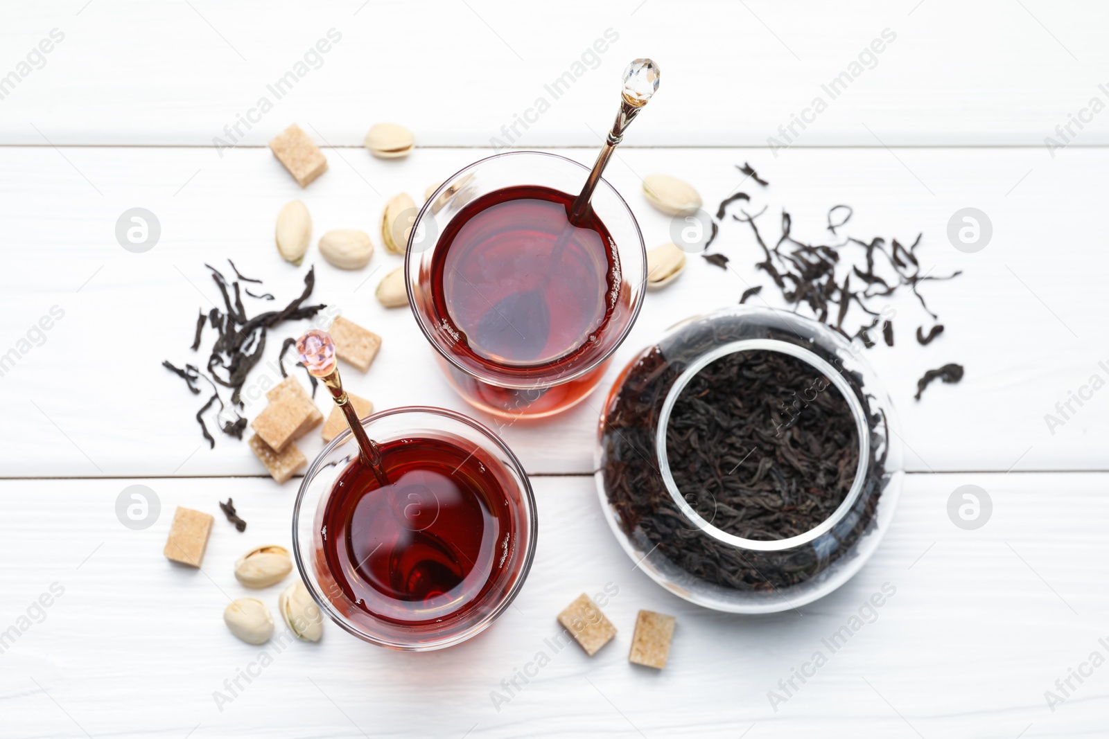Tasty Turkish tea, sugar and pistachios on white wooden table, flat lay Photo of Tasty Turkish tea, sugar and pistachios on white wooden table, flat lay