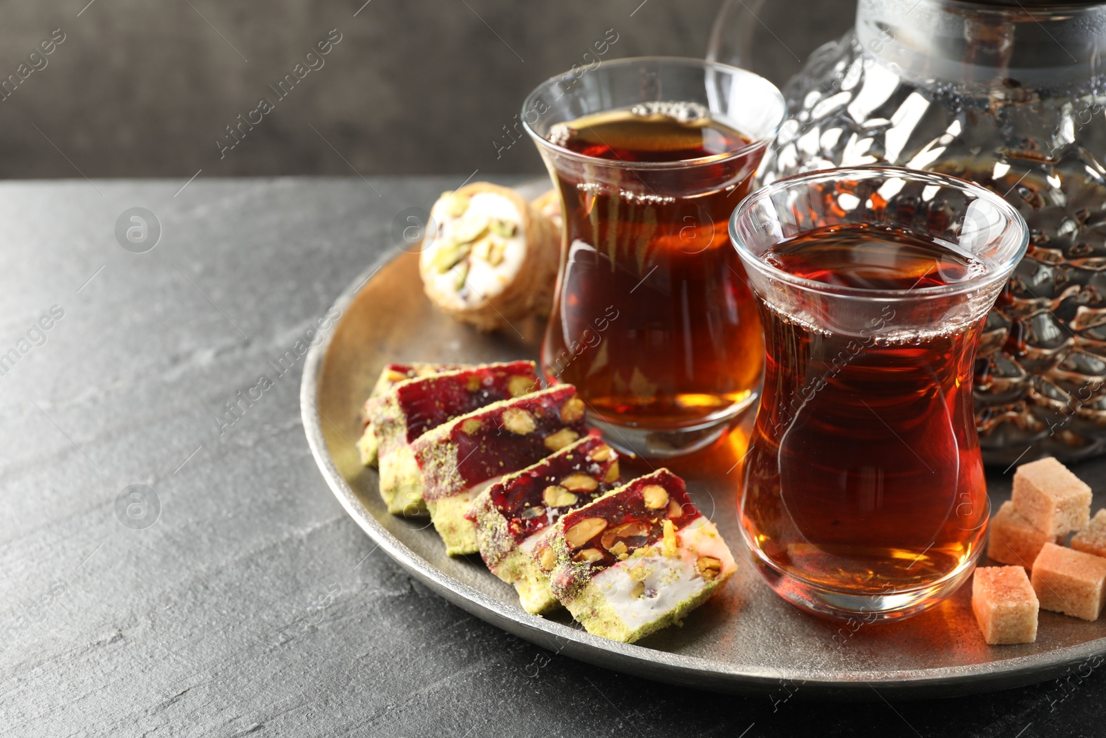 Tasty Turkish tea and delight on black table, closeup. Space for text Photo of Tasty Turkish tea and delight on black table, closeup. Space for text