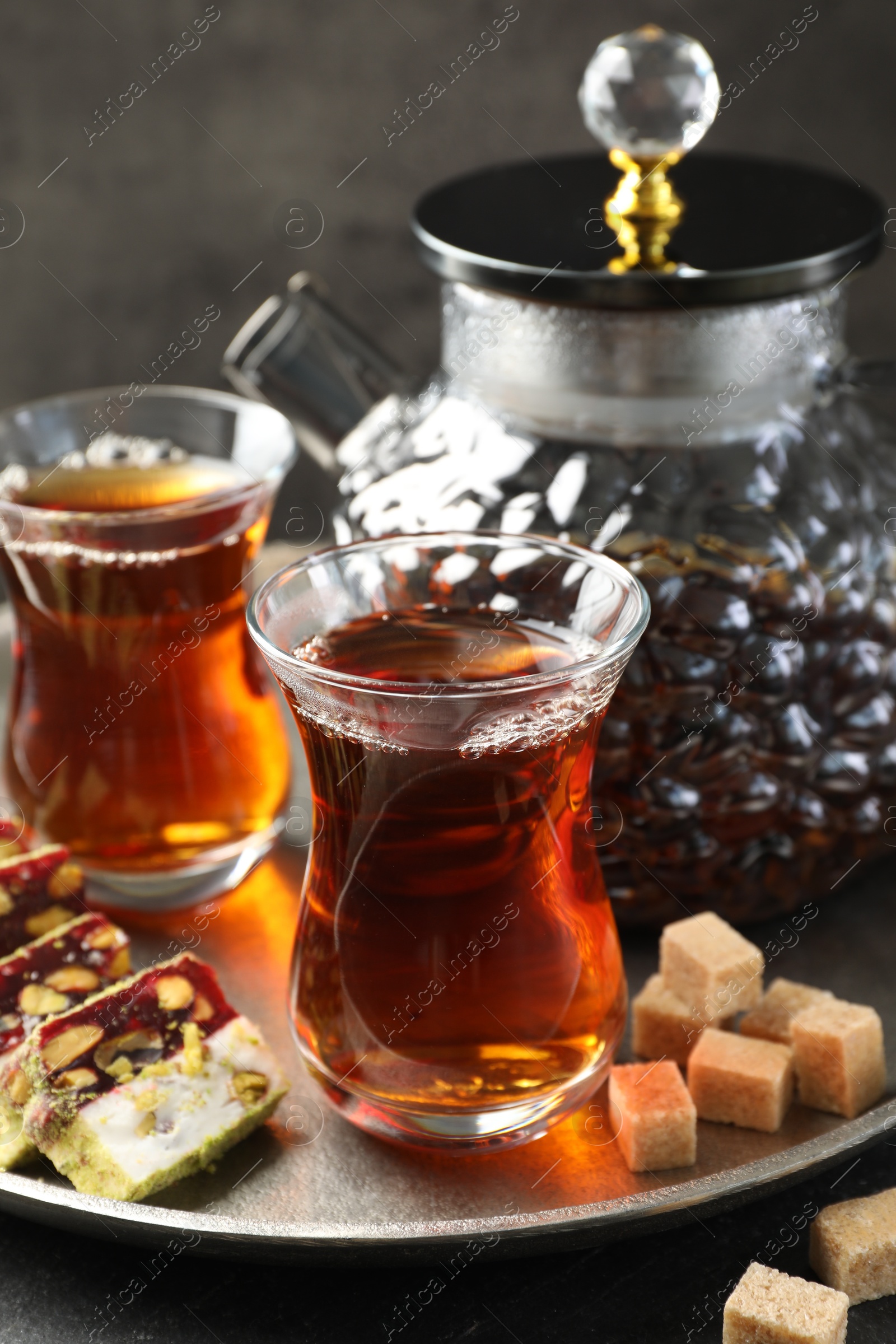 Tasty Turkish tea and delight on black table, closeup Photo of Tasty Turkish tea and delight on black table, closeup