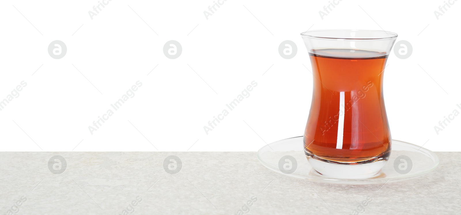 Tasty Turkish tea in cup on table against white background Photo of Tasty Turkish tea in cup on table against white background