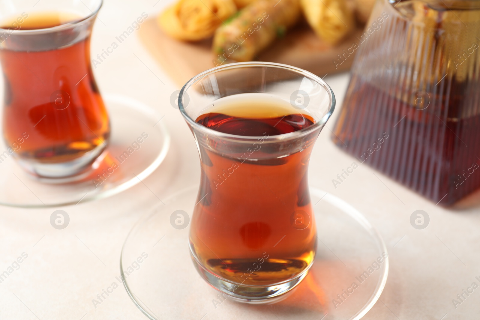 Traditional Turkish tea in glass cups, teapot and fresh baklava on white table, closeup Photo of Traditional Turkish tea in glass cups, teapot and fresh baklava on white table, closeup