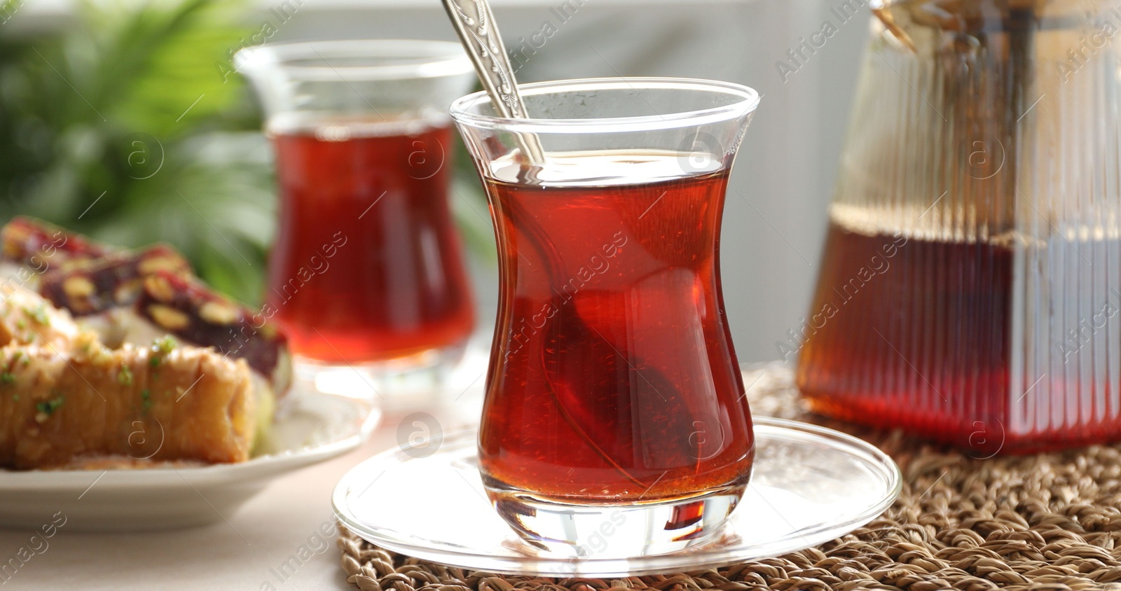 Traditional Turkish tea in glass cups, teapot and sweets on table indoors, closeup Photo of Traditional Turkish tea in glass cups, teapot and sweets on table indoors, closeup