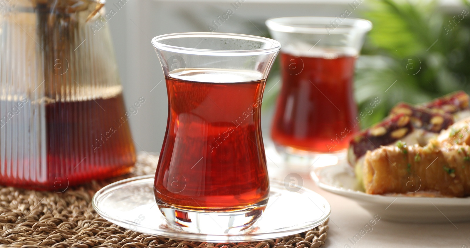 Traditional Turkish tea in glass cups, teapot and sweets on table indoors, closeup Photo of Traditional Turkish tea in glass cups, teapot and sweets on table indoors, closeup