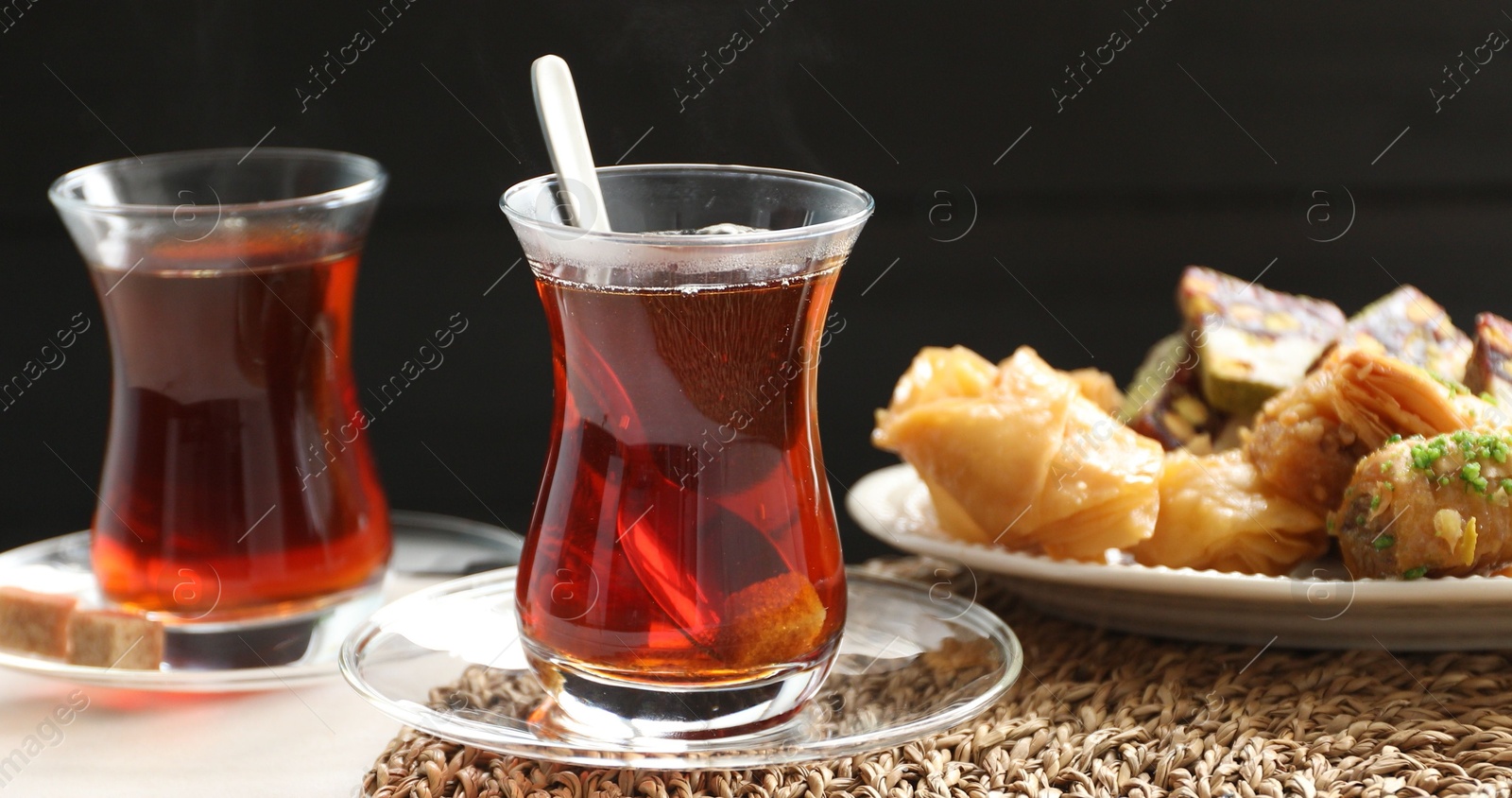 Traditional Turkish tea in glass cups and sweets on white table, closeup Photo of Traditional Turkish tea in glass cups and sweets on white table, closeup