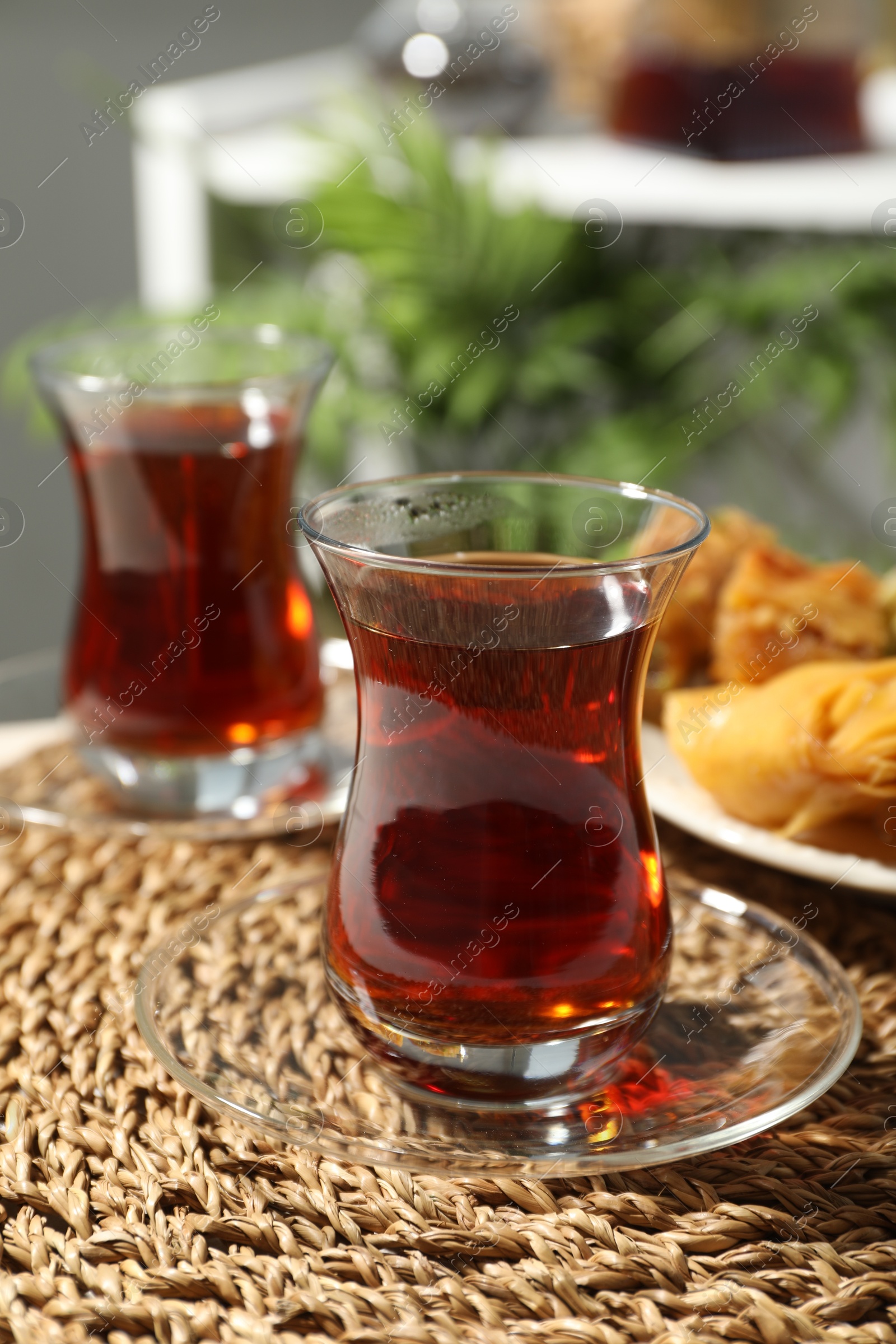 Traditional Turkish tea in glass cups and fresh baklava on table, closeup Photo of Traditional Turkish tea in glass cups and fresh baklava on table, closeup