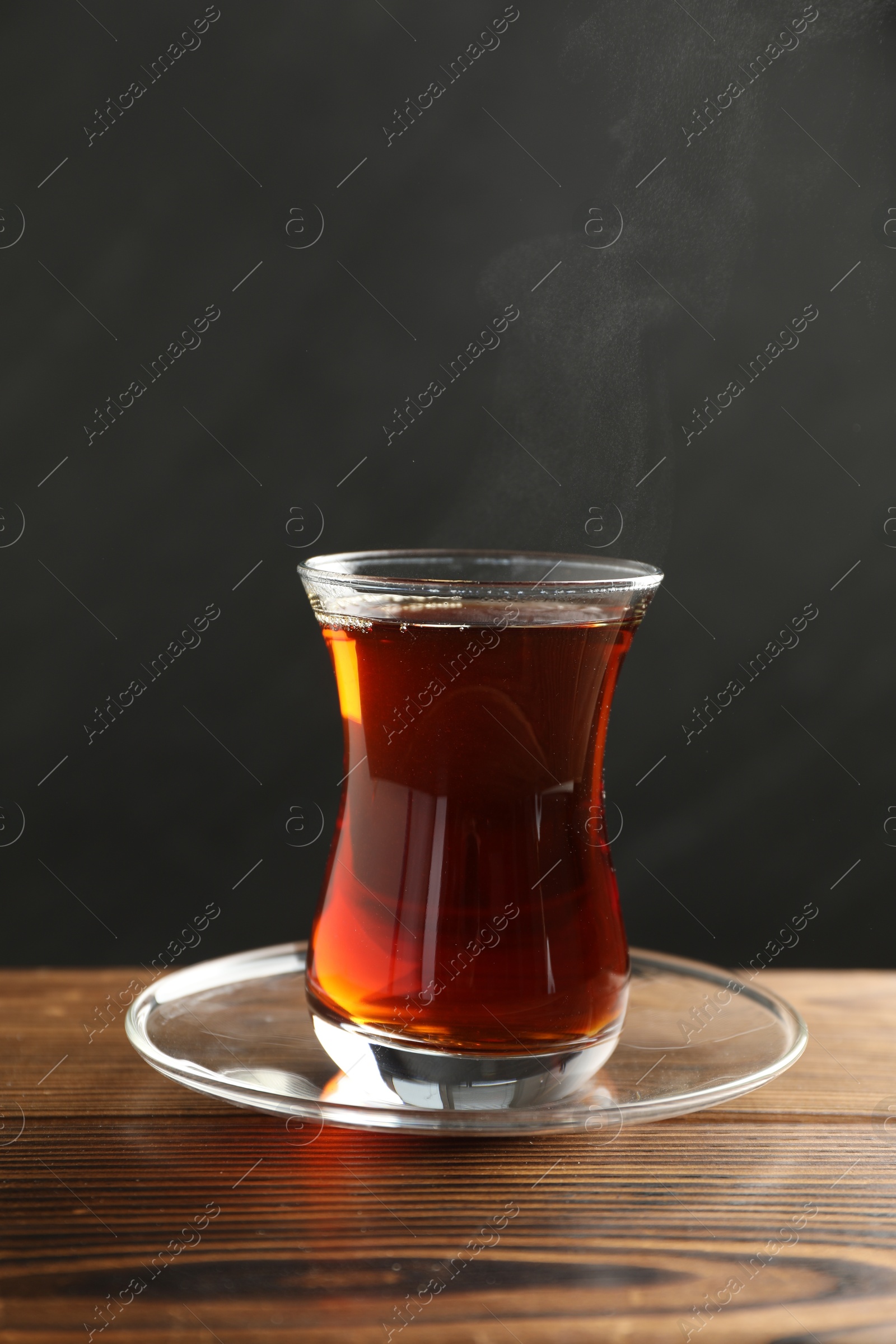 Traditional Turkish tea in glass cup on wooden table Photo of Traditional Turkish tea in glass cup on wooden table