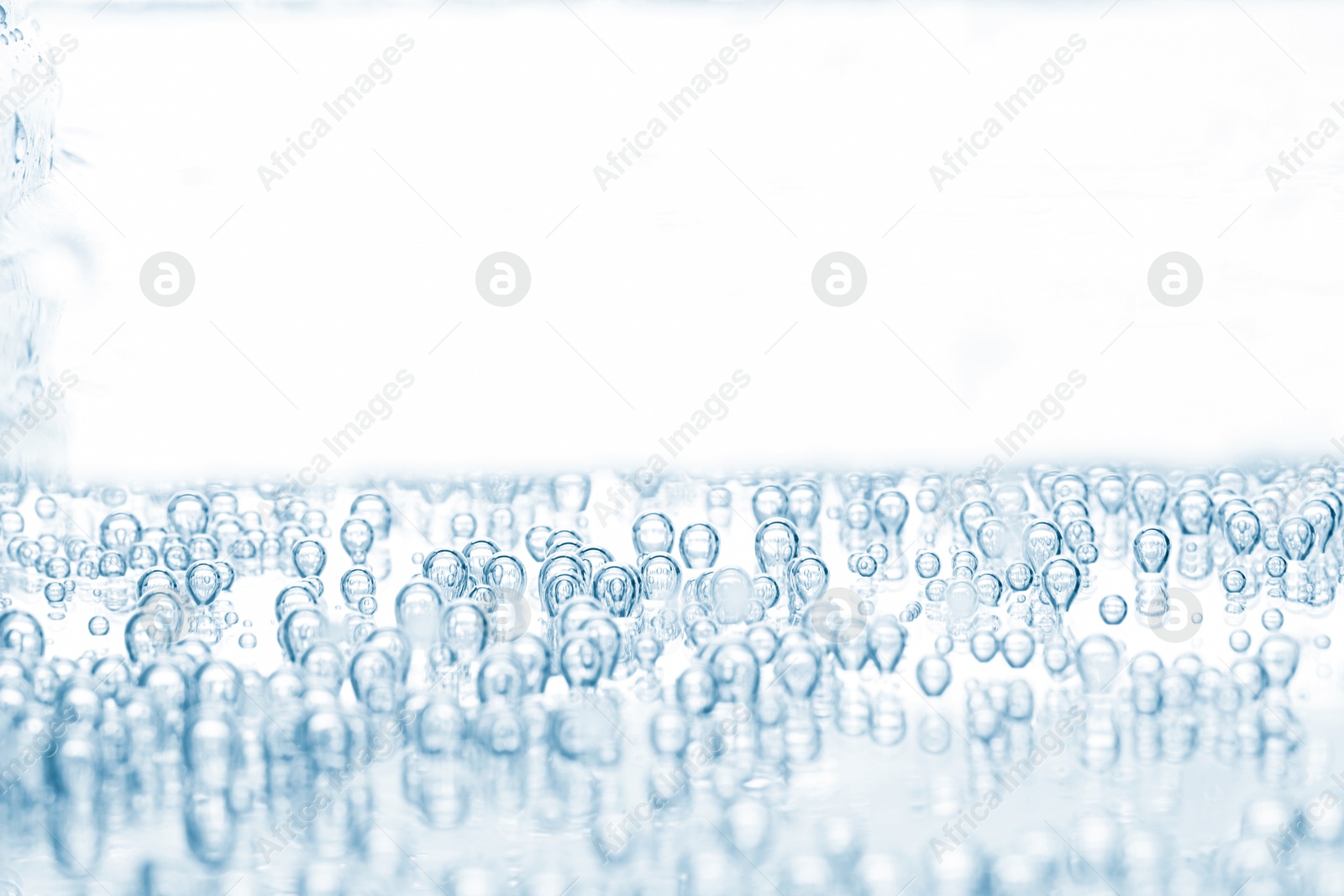 Soda water with bubbles in glass on white background, closeup Image of Soda water with bubbles in glass on white background, closeup