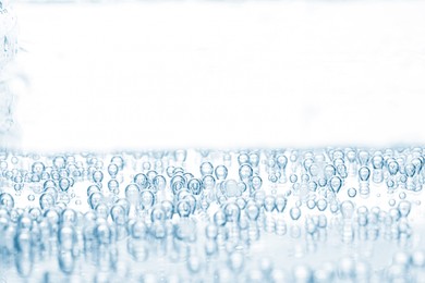 Image of Soda water with bubbles in glass on white background, closeup