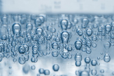 Image of Soda water with bubbles in glass, closeup