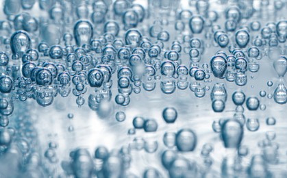 Image of Soda water with bubbles in glass, closeup