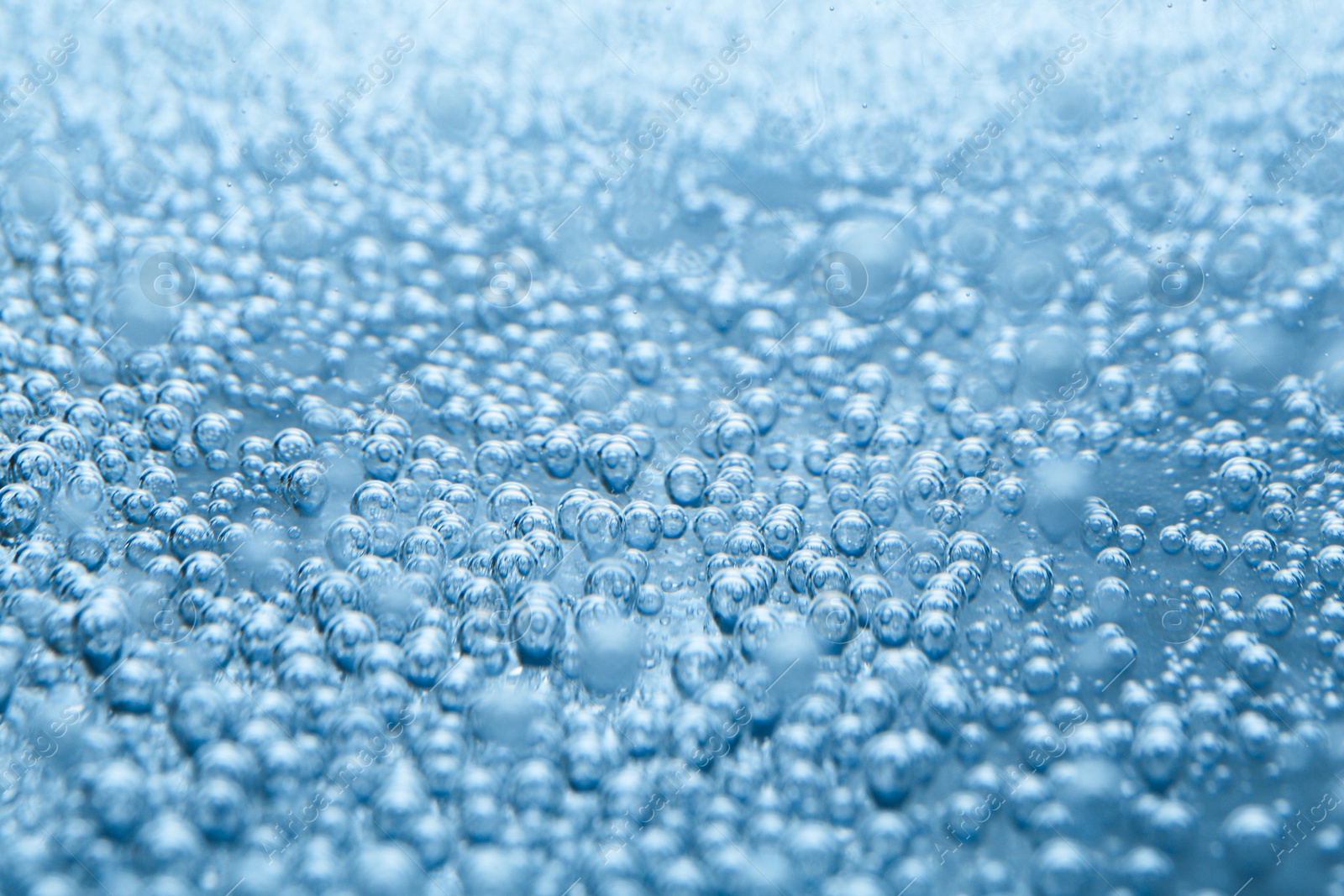 Soda water with bubbles as background, closeup Image of Soda water with bubbles as background, closeup