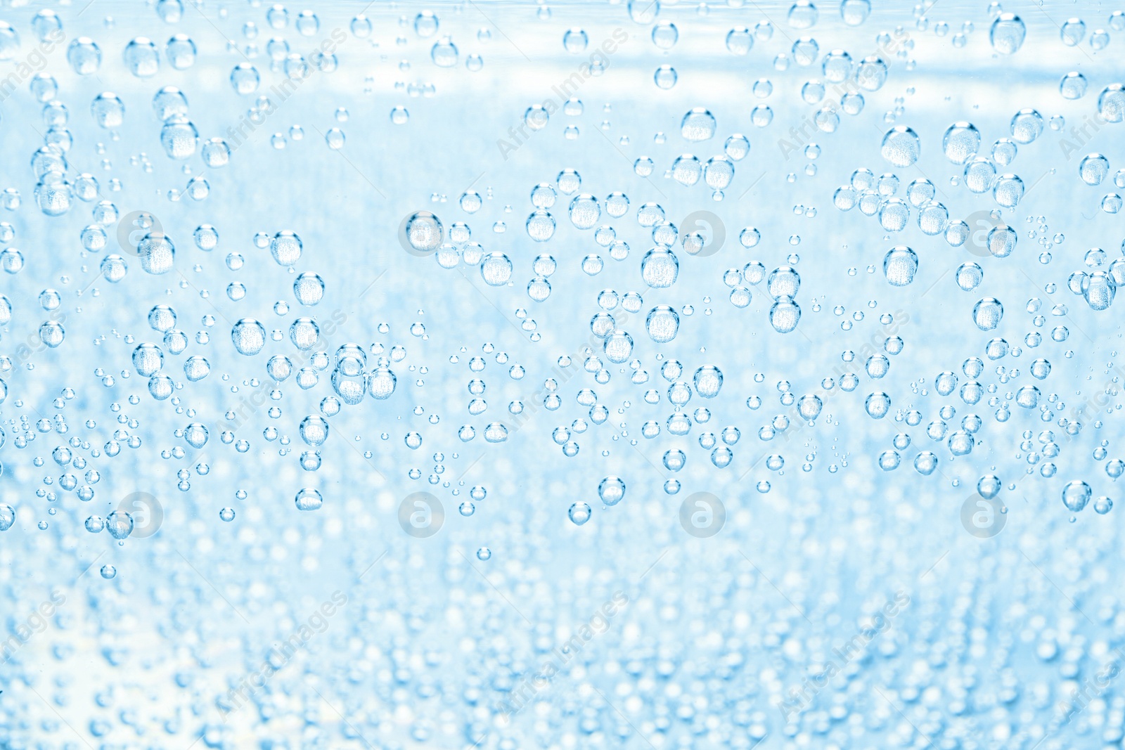 Soda water with bubbles as background, closeup Image of Soda water with bubbles as background, closeup