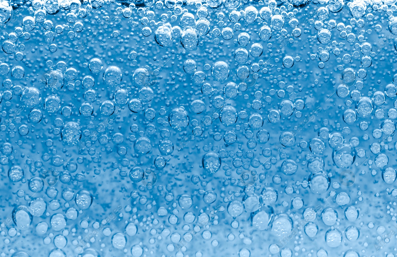Soda water with bubbles as background, closeup Image of Soda water with bubbles as background, closeup