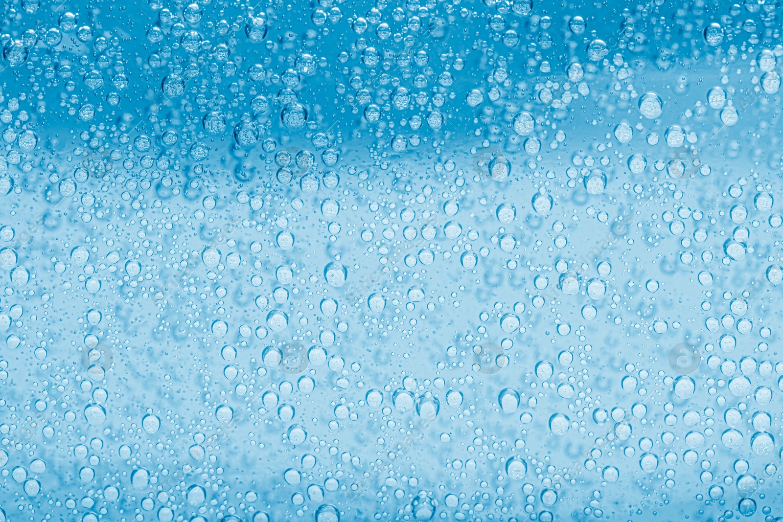 Soda water with bubbles as background, closeup Image of Soda water with bubbles as background, closeup