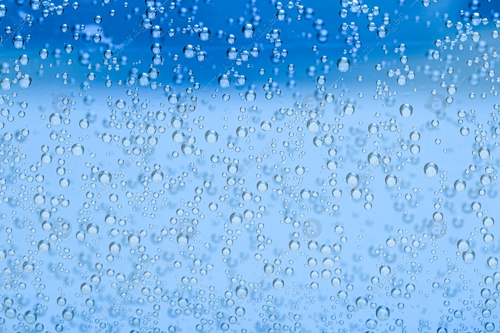 Soda water with bubbles as background, closeup Image of Soda water with bubbles as background, closeup