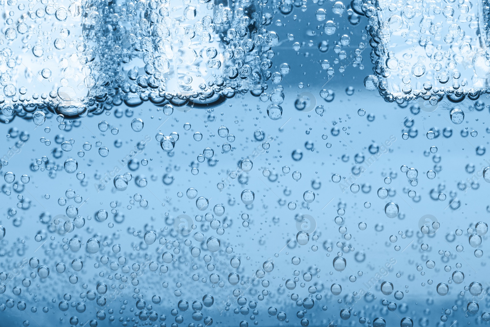 Soda water with ice cubes as background, closeup Image of Soda water with ice cubes as background, closeup