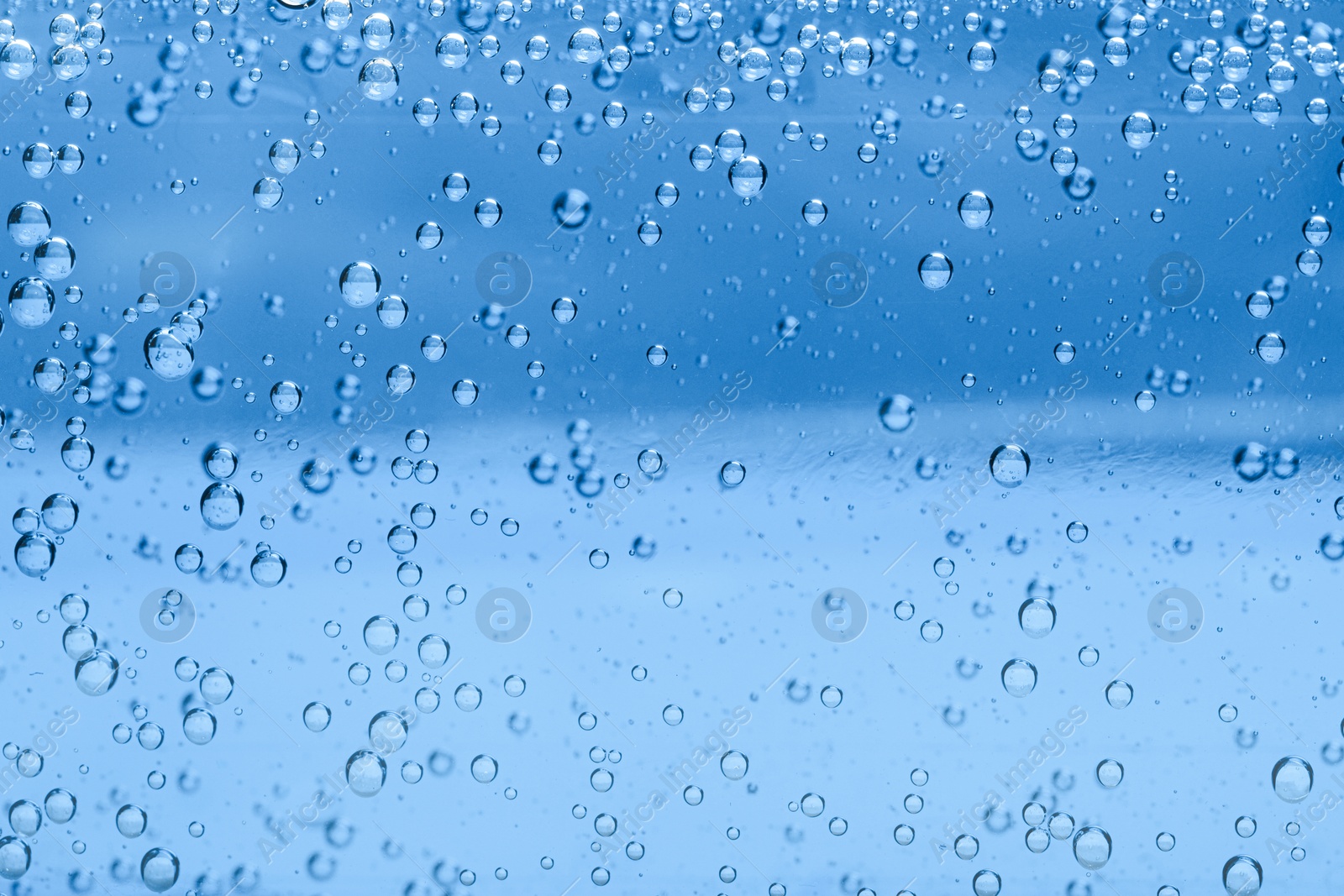 Soda water with bubbles as background, closeup Image of Soda water with bubbles as background, closeup