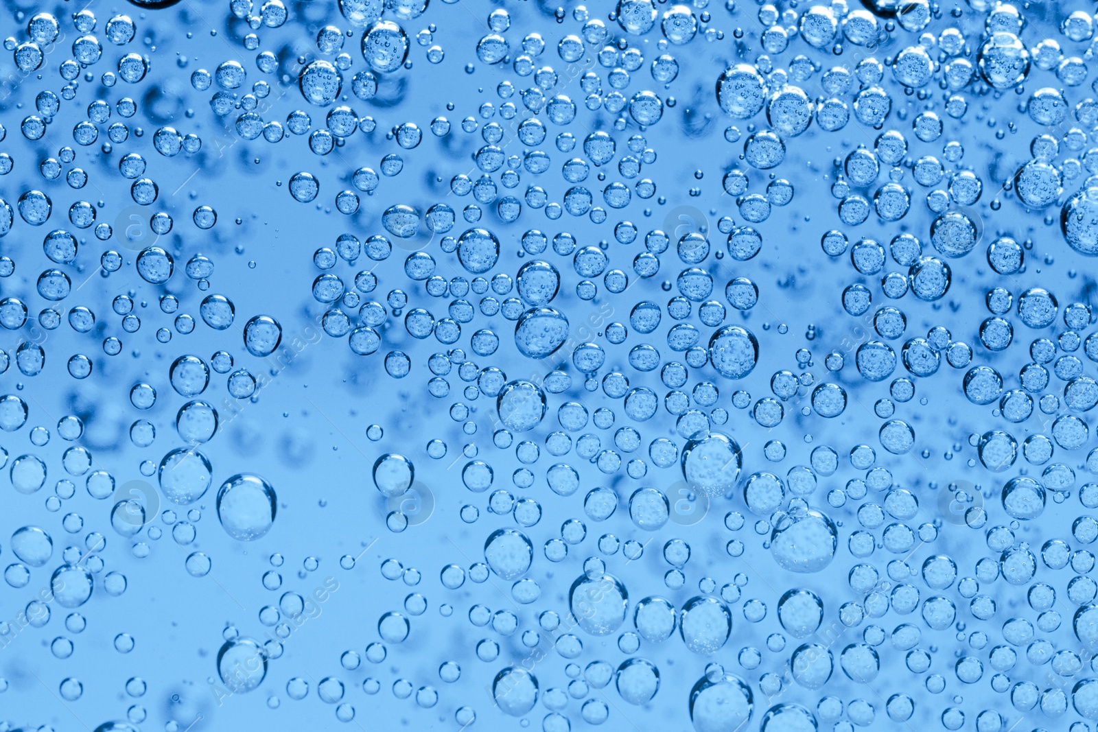 Soda water with bubbles as background, closeup Image of Soda water with bubbles as background, closeup
